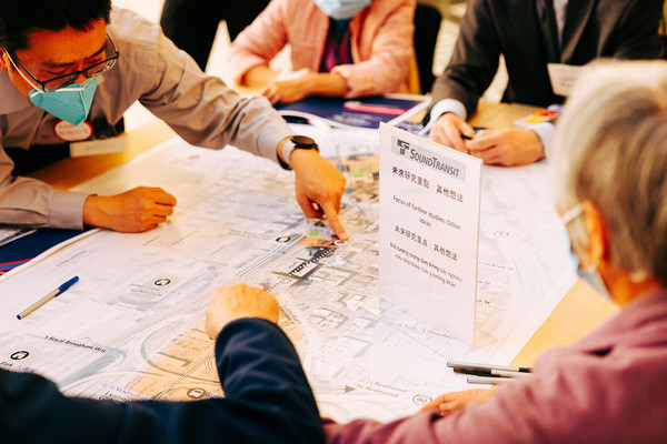 Photo of people around a table viewing information