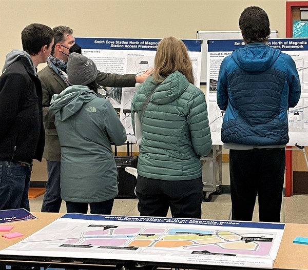 Photo of people in masks viewing a display board, West Seattle and Ballard Link Extensions Open House