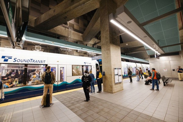Photo of people waiting at station as the link light rail arrives at a station