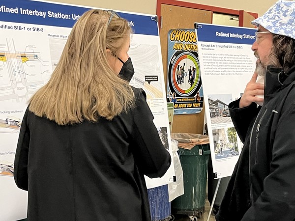 Photo of people viewing an information board, West Seattle and Ballard Link Extensions