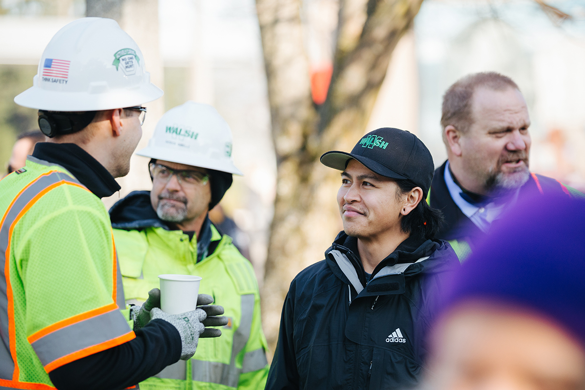 Photo of construction crews speaking to a member of the public. 