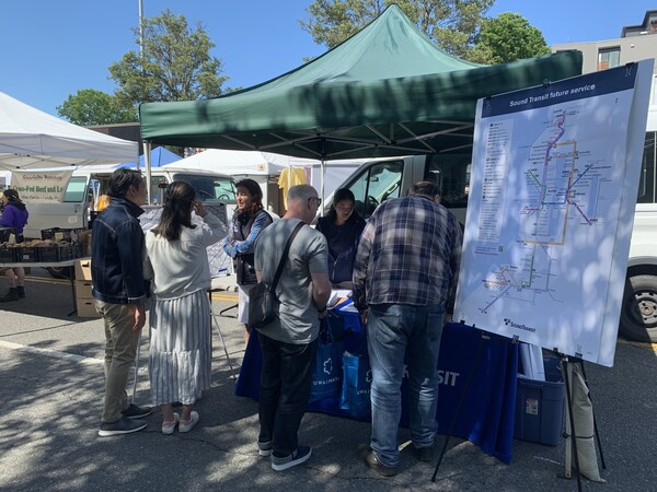 Photo of people at the Sound Transit information booth at the West Seattle Farmers Market