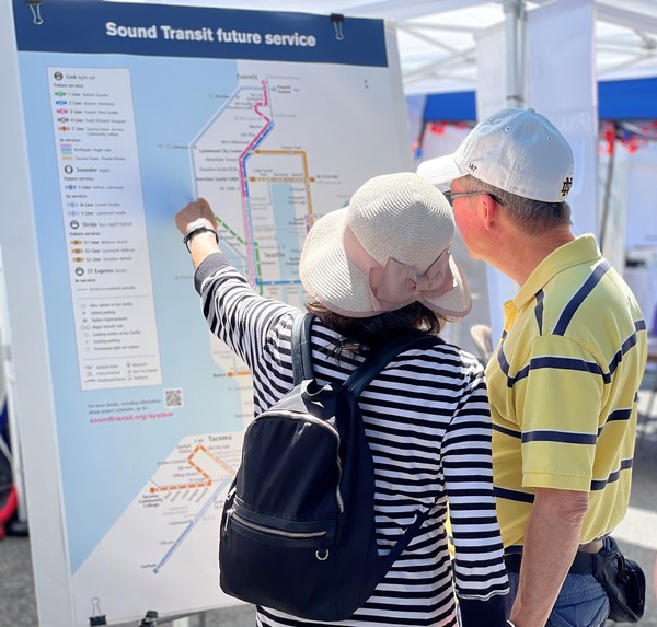 Photo of two people looking at a Sound Transit information board