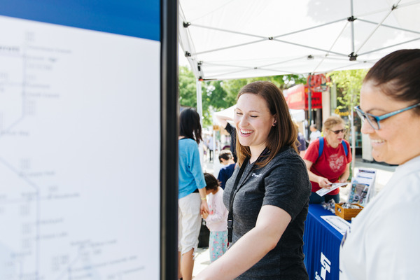 Sound Transit staff smile as they engage with the public at a summer festival.