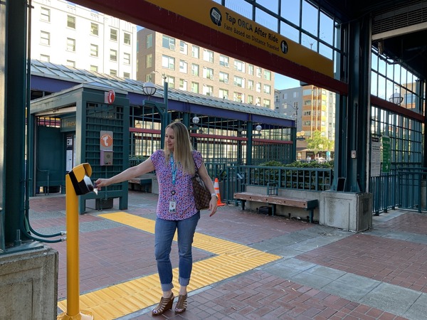 A woman taps her ORCA card at the International District/Chinatown light rail station.