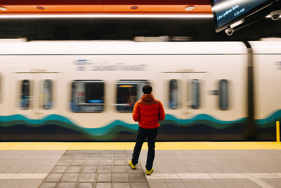 Photo of a man standing in front of the Link Light Rail at a station
