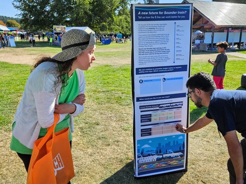  Picture showing a Sound Transit staff person talking to a member of the public at an event. 