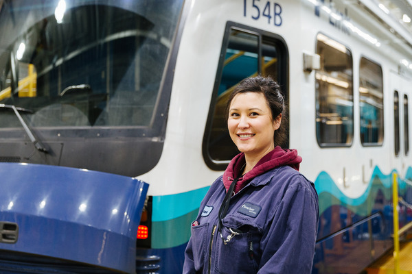 image of a woman standing in front of a link light rail train