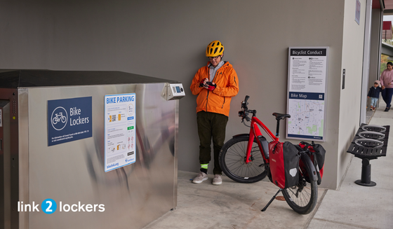 photo of person with bike standing next to a Bike Locker