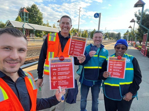 staff out in the field during rail safety week holding signs with ST's safety messages. 