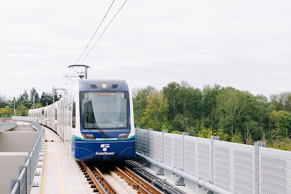 Sound Transit Link light rail on elevated tracks heading towards an elevated station.