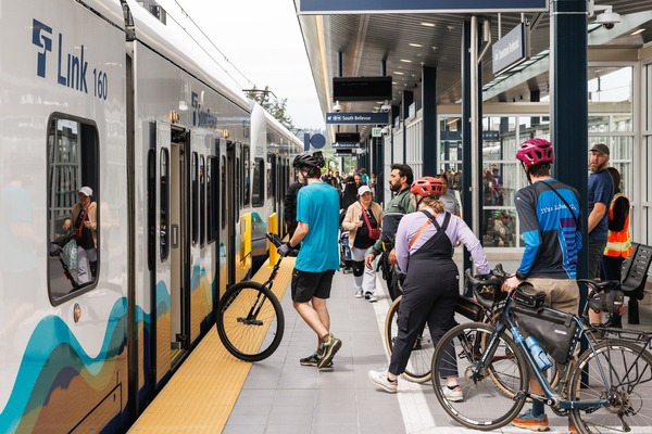 People entering a Link light rail train while it is stopped at a station.