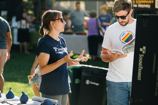 A Sound Transit representative speaks with a community member at a local event