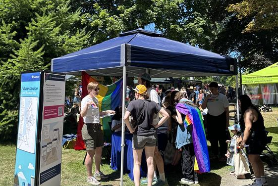 Sound Transit staff present project information and talk with members of the community under a tent at Tacoma Pride.