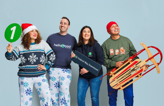 People holding and holding Sound Transit merch while smiling and being playful.