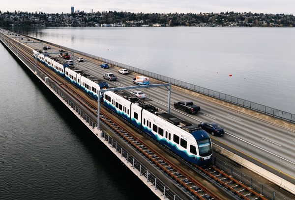 Photo of Link light rail crossing the lake next to cars on the I-90 bridge.