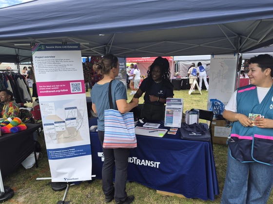 A photo of people interacting at a Sound Transit booth during an event.