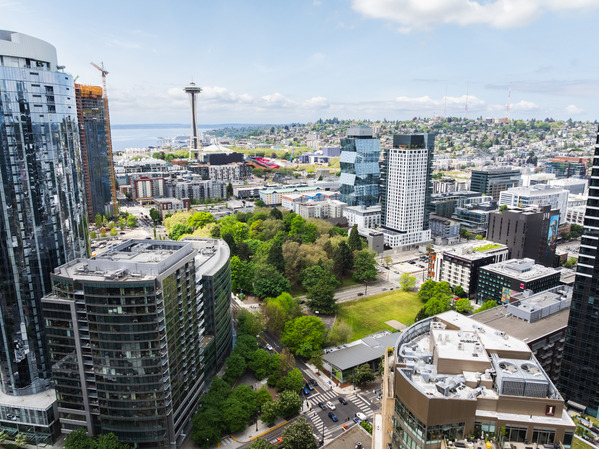 Aerial view of Seattle Center and surrounding neighborhoods, with the Space Needle, buildings, streets and green spaces visible. 
