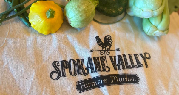 Produce surrounding t-shirt with Spokane Valley Farmer's Market logo