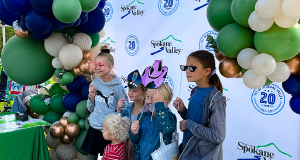 Kids taking posing for a photo at a booth at Valleyfest