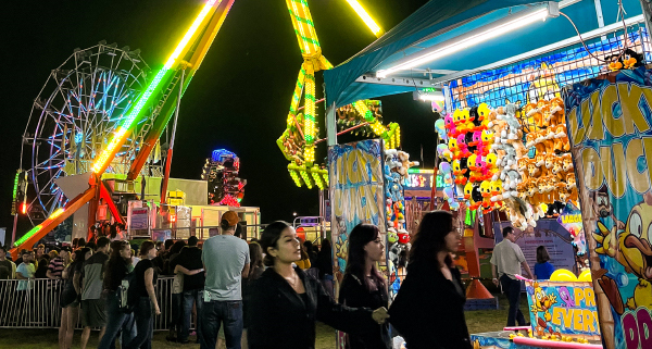 People walking around a fair at night