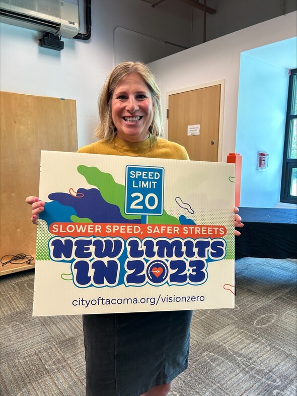 CM Rumbaugh holding a Vision Zero yard sign