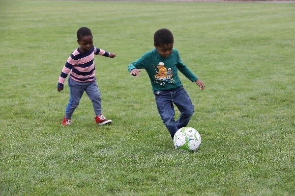 Two children playing soccer