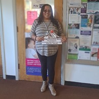 Woman holding a sign in an office.