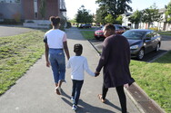 Mom, boy and girl walking in a neighborhood.