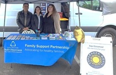 Two people standing behind a table advertising Esperanza Movil services.
