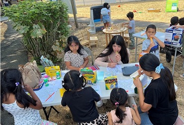 Group of children doing an art activity at a table at a free lunch event in Tacoma.