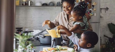 Mother and her two children cooking together in a kitchen.