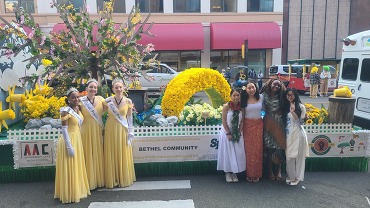 Seven young people posing in front of the Bethel Community Float for the Daffodil Festival.