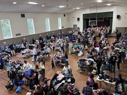 Crowded gym at a Food Backpacks 4 Kids clothing giveaway.