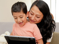 Mom and son looking at tech device.