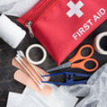 First aid bag and supplies laid out on a flat surface.