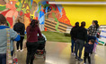 Families looking a wall murals at Eastside Community Center.