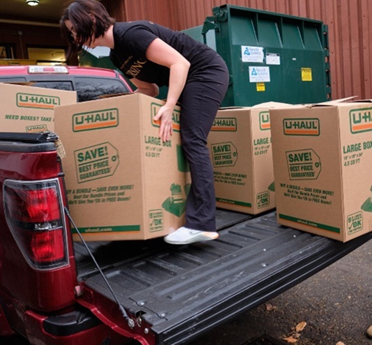 Woman loading boxes on a truck.