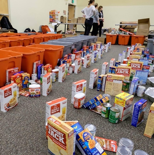 Food items and boxes on the floor of a room.