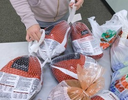 Frozen turkeys and other groceries on a table.
