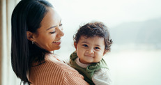 Smiling mom holding smiling baby.