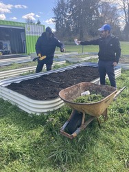 Two men gardening around a raised planter box.