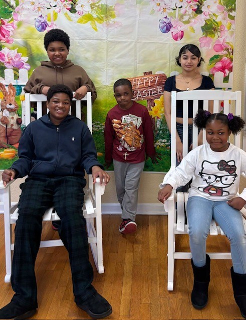 Five kids posing in front of an Easter backdrop.