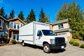Moving truck parked in front of houses