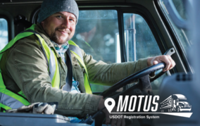 Truck driver in safety vest smiling, with “Motus USDOT Registration System” text.