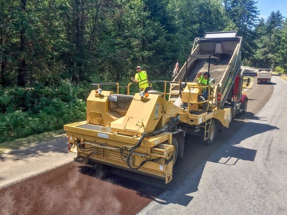 Heavy machinery chip seals a Whatcom County roadway