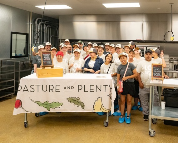 Group of people in Pasture and Plenty and Foodshed t-shirts smiling in a kitchen