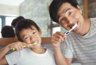 Photo of father and son brushing teeth 