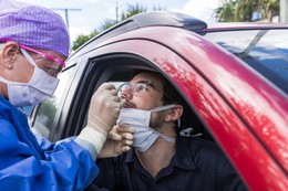 Driver getting a drive-up nasal swab test