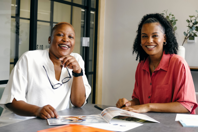 Two Black women smiling in an office setting